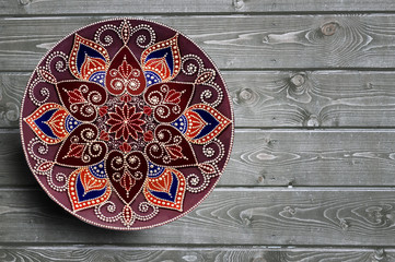 Decorative ceramic plates hand painted dot pattern with acrylic paints on a gray wooden background. Copy space.