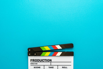 Top section of white clapperboard at the bottom of turquoise blue background with copy space. Top...