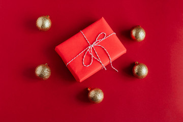 top view red gift box and golden christmas balls on a red background
