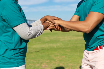 Two volunteers expressing unity and support. Outdoor closeup of stack of hands gesture. Friendship or community concept