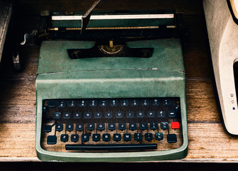 Old Vintage Typewriter machine with printlike characters one at a time on paper inserted around a roller.