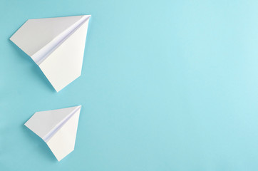 White paper planes on blue background composition.