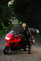 Fototapeta na wymiar man in leather clothes on the sports bike outdoors