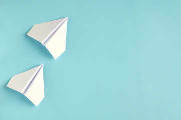 White paper planes on blue background composition.