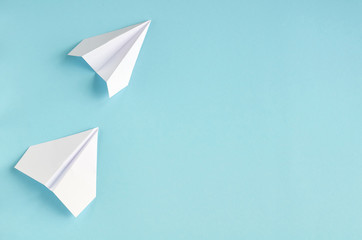 White paper planes on blue background composition.