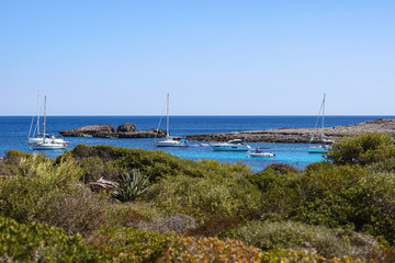View of blue sea and boats, Binibequer beach, Menorca island, Spain