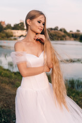 Fototapeta na wymiar beautiful girl in a white dress, a wreath and golden hair