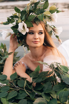 beautiful girl in a white dress, a wreath and golden hair