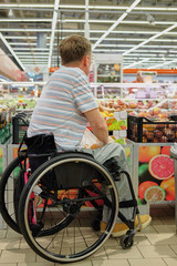 disability man, person with a disability,  shopping in wheelchair, handicapped shopper in supermarket	