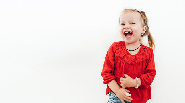 Cheerful laughing little girl in red blouse . Studio Shooting on the white background.