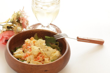 Potato and carrot salad on wooden bowl