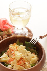Potato and carrot salad on wooden bowl