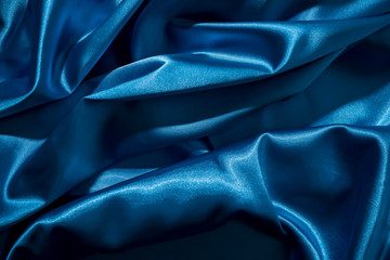 Background image of crumpled fabric. Blue silk