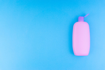 Flat lay composition of baby care products on a blue background. View from above shampoo or shower bottle gel