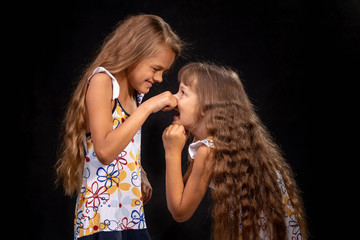 Girl pinched a hand on the nose of another girl
