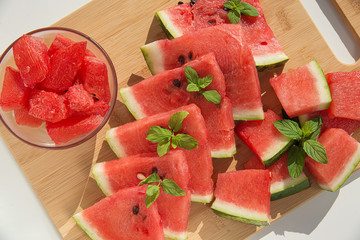 Fresh slices of watermelon on a wooden board.