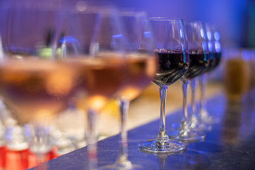 Many glasses of different wine on bar counter