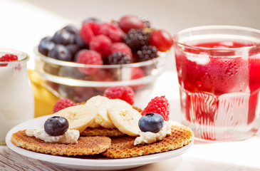 Waffles with cheese, yogurt and raspberries. A delicious wholesome breakfast on a light background. Very soft selective focus.