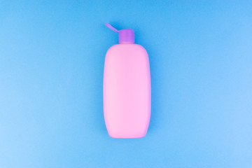 Flat lay composition of baby care products on a blue background. View from above shampoo or shower bottle gel
