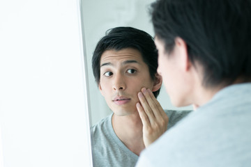 鏡を覗き込む男性