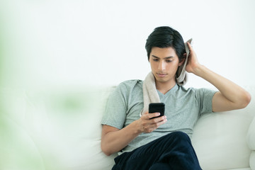 くつろぎながら髪を拭く男性