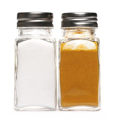 Salt and turmeric in spice holders, glass bottles isolated on white background