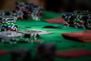 Obraz premium A poker table with casino chips and cards on greencloth, background with selective focus