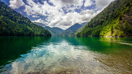Natural landscape. Panorama view of the lake Small Ritsa. Trees reflecting in the blue from lapis...