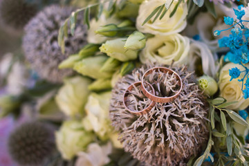 Close up view on wedding rings on rustic brides bouquet