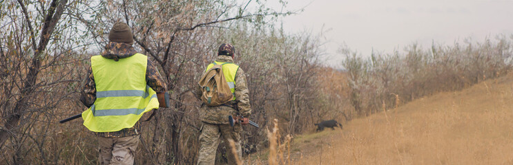Hunters with a german drathaar and spaniel, pigeon hunting with dogs in reflective vests	