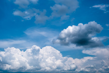 Blue sky with white fluffy cumulus and nimbus clouds.