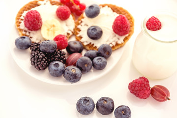 Waffles with cheese, yogurt and raspberries. A delicious wholesome breakfast on a light background. Very soft selective focus.