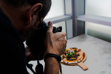 A food photographer is shooting pizza
