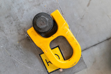 yellow eyebolt in an industrial environment for connection to a lifting hook for heavy loads