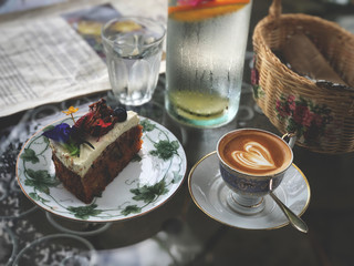 Delicious Breakfast;  Piccolo Latte coffee  and Carrot cake in beautiful plate. Natural dark light and vintage style.