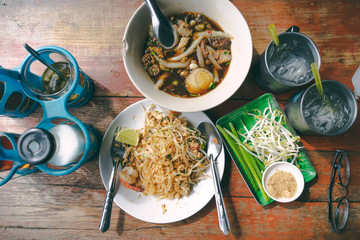 top view thai street food on old wooden table padthai and guay jub noodle, popular traditional thai dish
