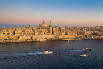 Valletta - capital of Malta. Aerial view of Valletta Skyline in the evening, Sunset. Boats on the sea