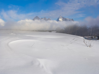 winter snowbound mountain landscape, plain in a snow before a rock ridge