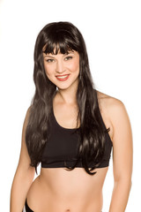 Fototapeta premium Young beautiful woman posing with long black wig on white background