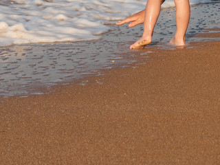 Children's feet on the beach waves summer