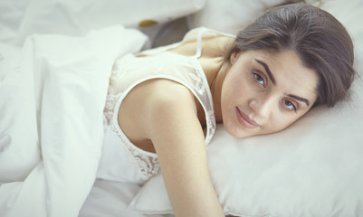 Obraz na płótnie Canvas beautiful young woman basking in bed in the morning. Beautiful
