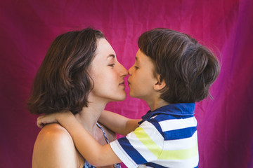 Cute boy kisses and hugs mom.