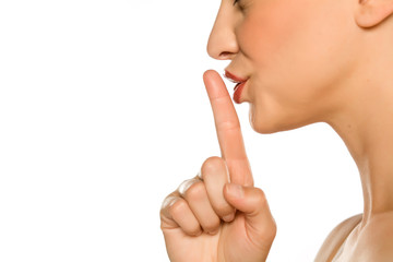 Closeup profile of woman with her finger on her lips