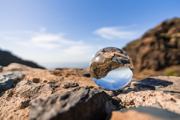 Lensball auf einem Stein mit Blick auf Berge / Himmel