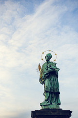 Fototapeta premium St. John of Nepomuk's statue on Charles Bridge in Prague, Czech Republic. Medieval Gothic bridge, finished in the 15th century, crossing the Vltava River