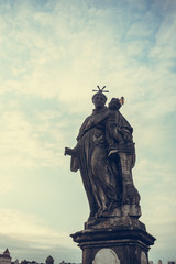 Fototapeta na wymiar Anthony of Padua statue on Charles Bridge in Prague, Czech Republic. Medieval Gothic bridge, finished in the 15th century, crossing the Vltava River