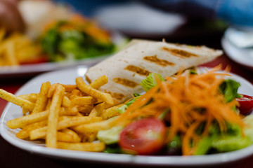 Serviced Wrap with potato and salad in plate