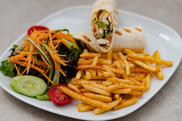 Serviced Wrap with potato and salad in plate