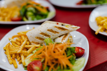 Serviced Wrap with potato and salad in plate