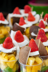 Colorful inviting and refreshing cups of fruit salad with fresh strawberries, coconut, pineapple and kiwi